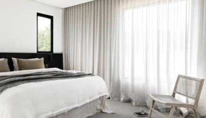 Minimalist-bedroom-with-white-bedding-black-headboard-cane-chair-and-floor-to-ceiling-linen-sheer-curtains